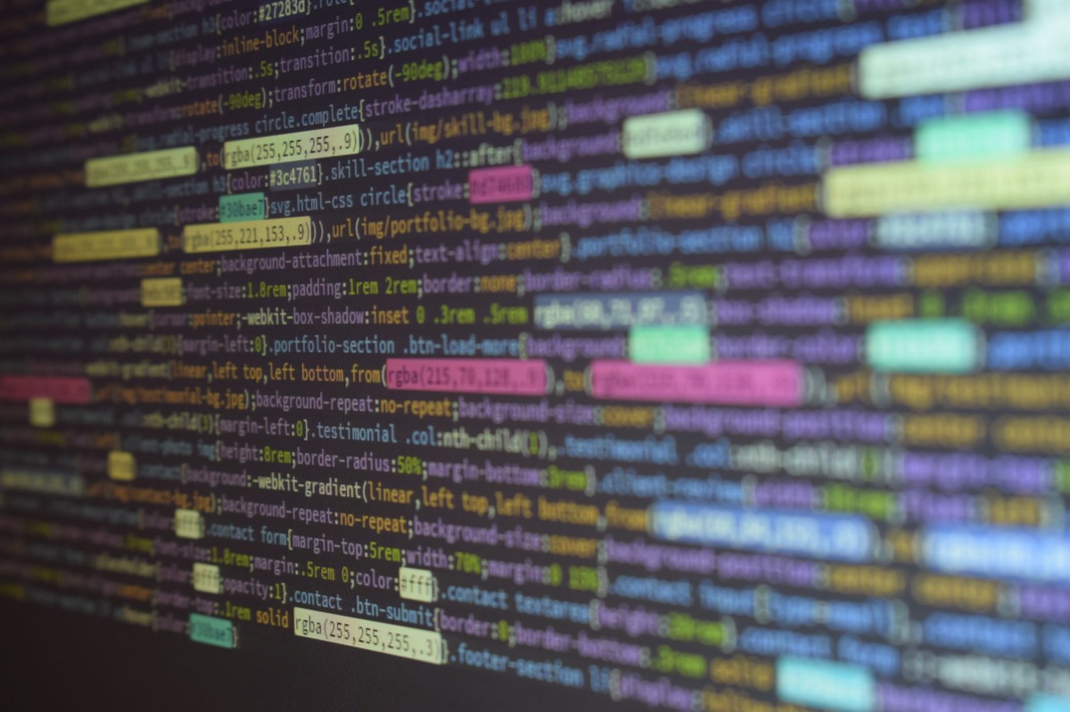 Detailed macro shot of colorful programming code on a dark monitor screen.