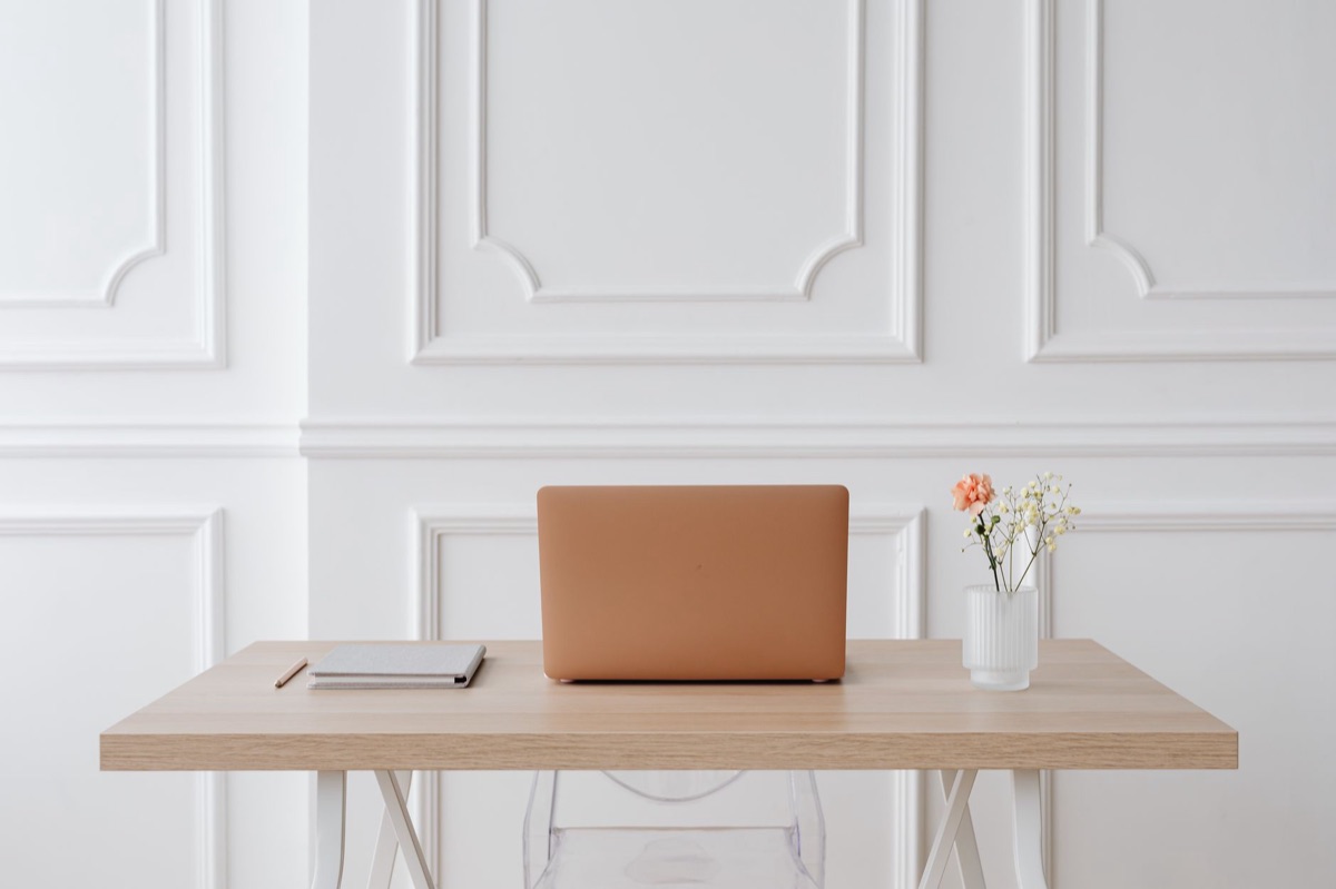 Postazione di lavoro minimalista con laptop e scrivania pulita.