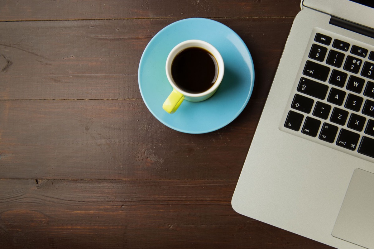 Minimalistische werkplek met een laptop op een houten bureau
