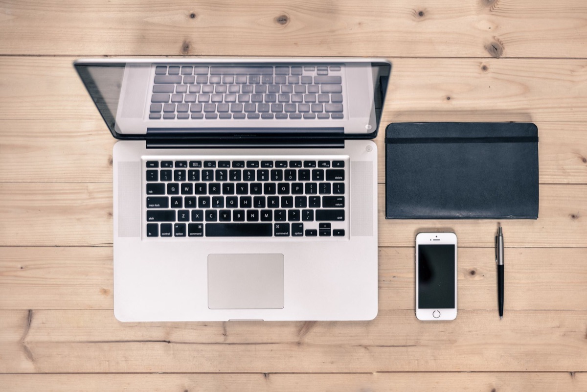 Espaço de trabalho minimalista com notebook sobre a mesa.