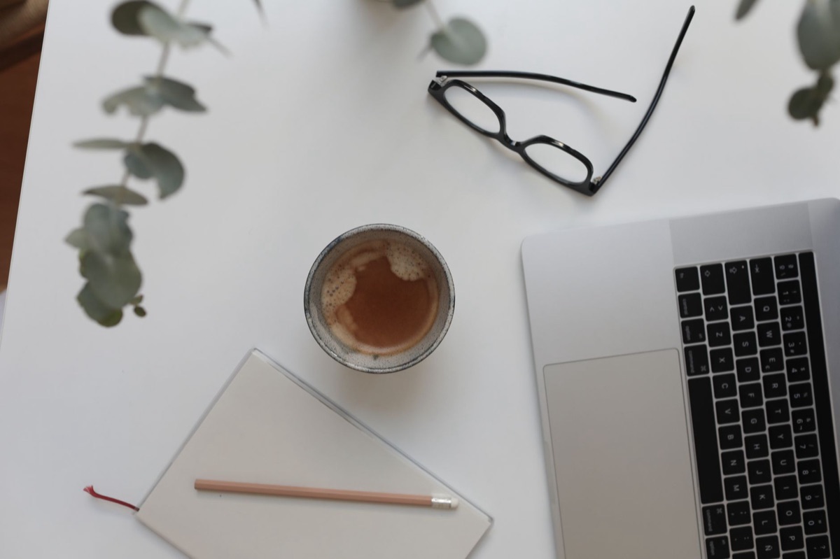 Minimalistischer Arbeitsplatz mit Laptop und Kaffee