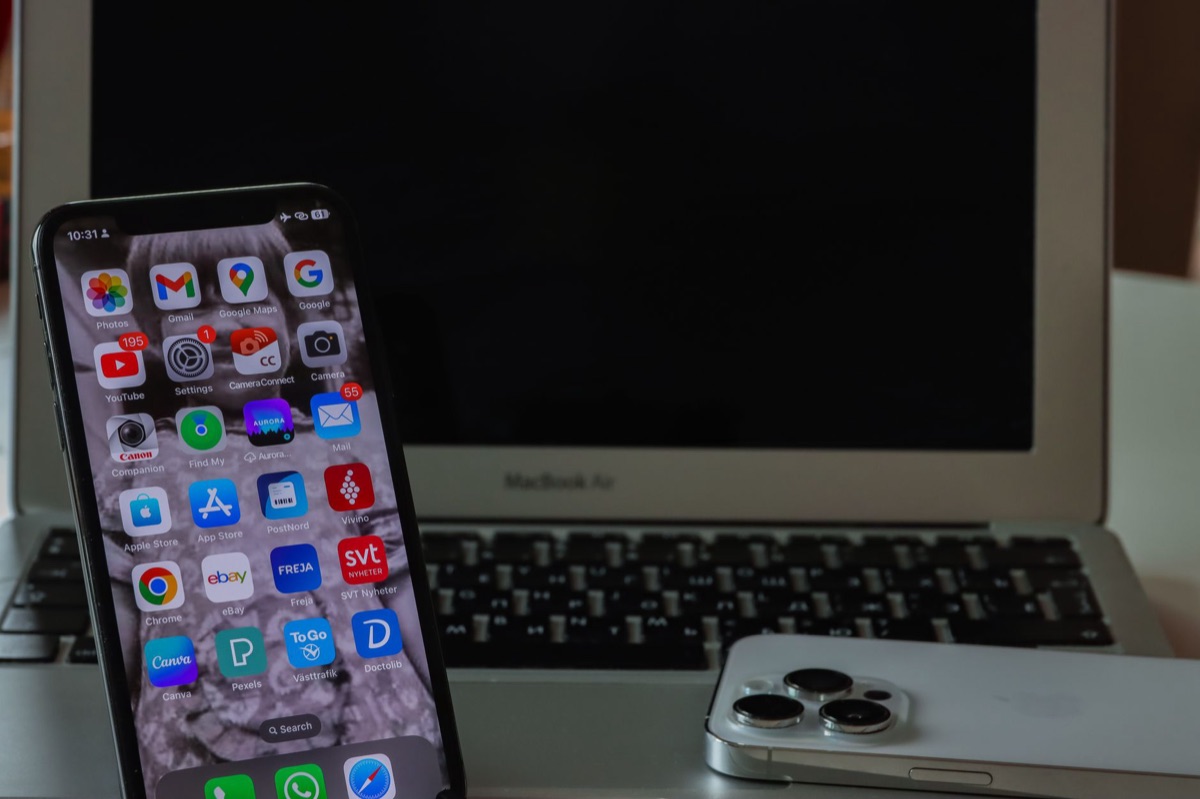 An Apple ecosystem setup showing synchronized AI tasks across a MacBook and an iPhone.