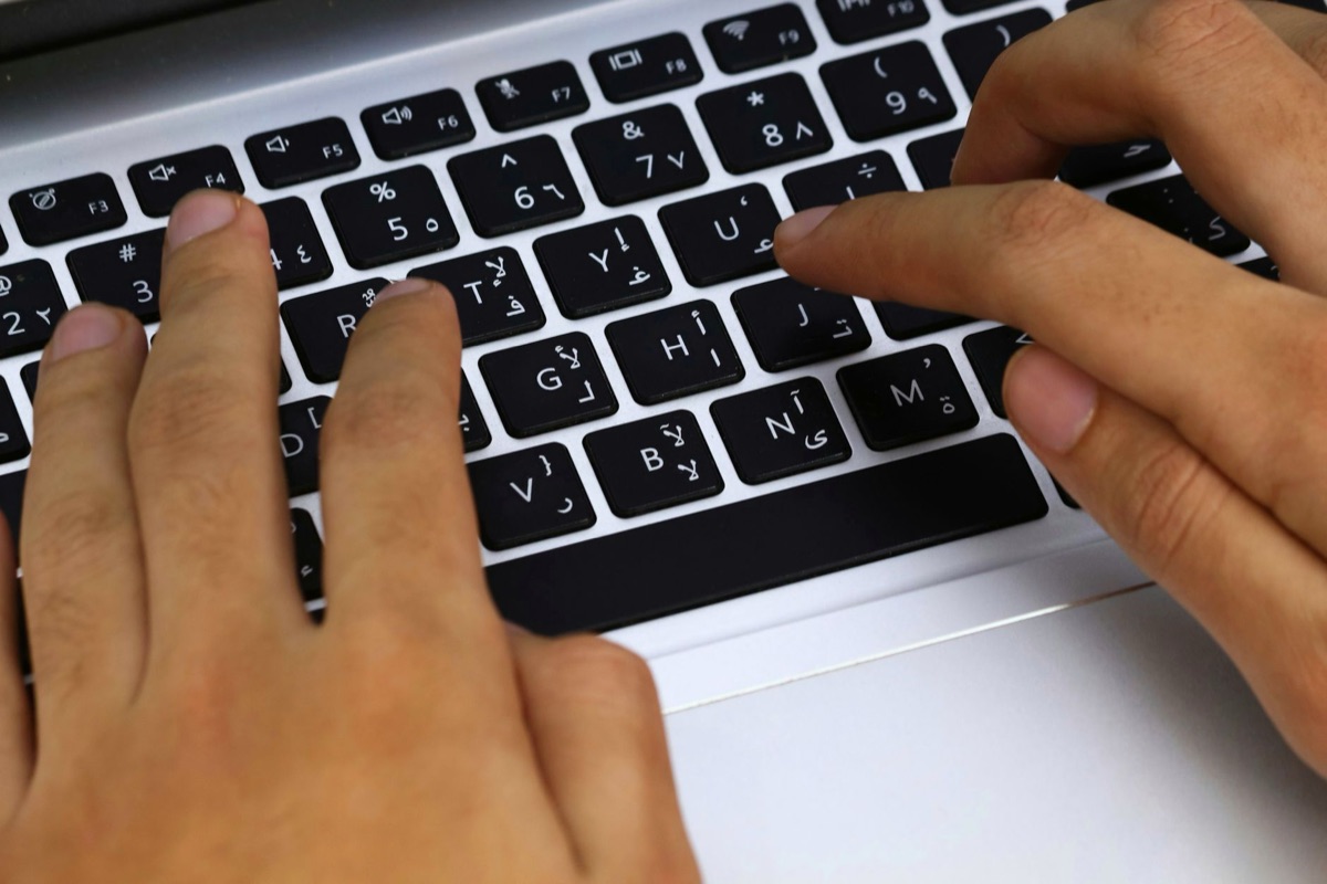 Manos trabajando en teclado de laptop