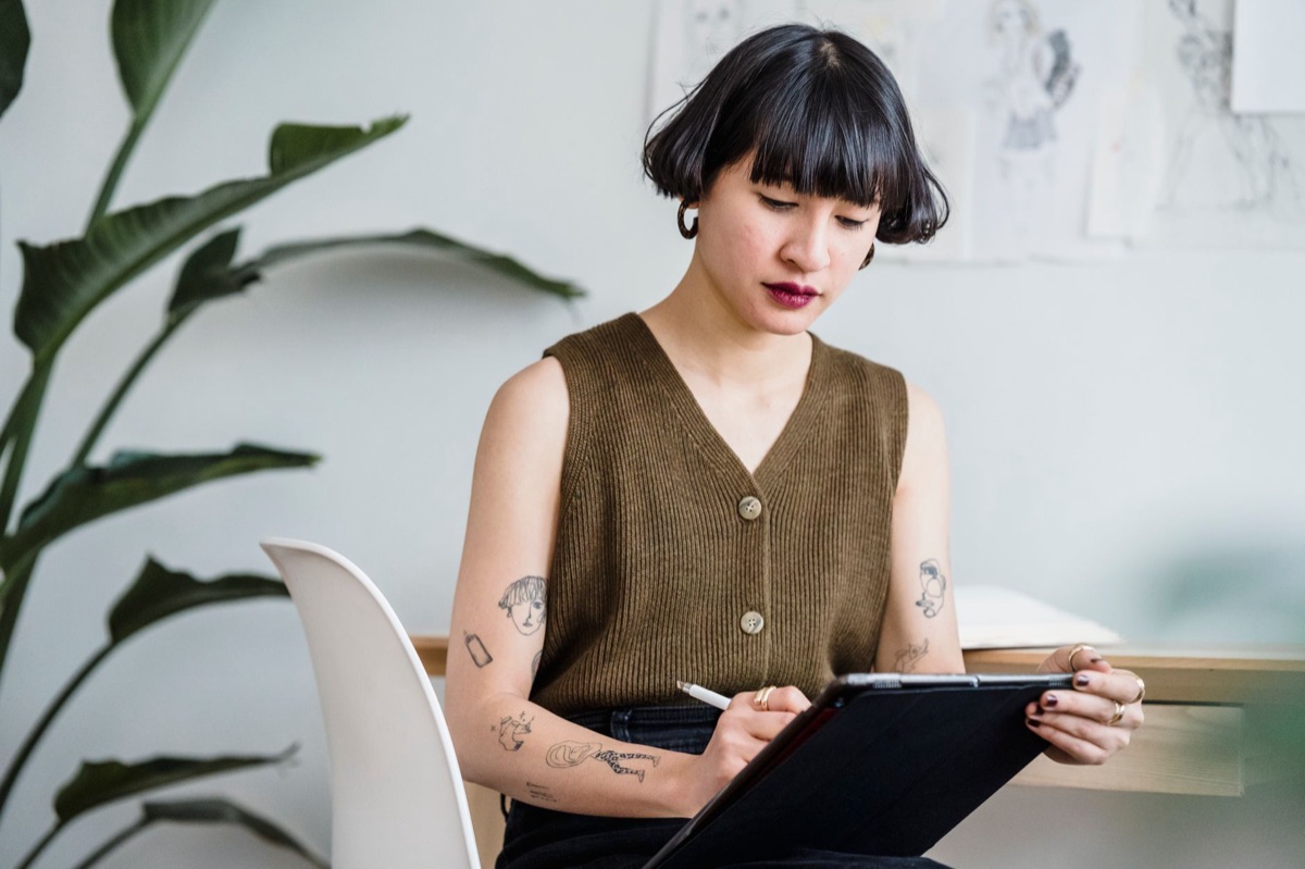 Designer using midjourney for creative workflow with a digital screen and laptop